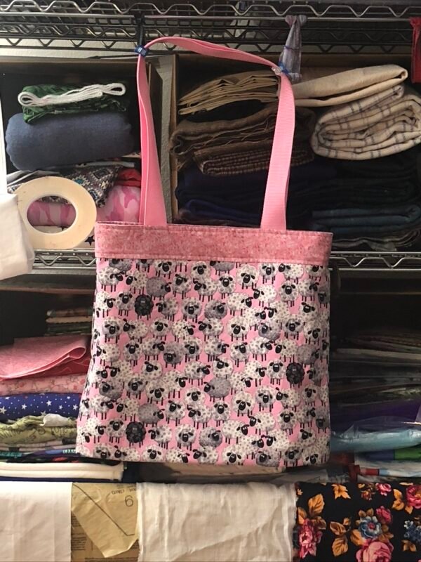 Reversible shopping tote, main fabric pink background, design is cartoon sheep
